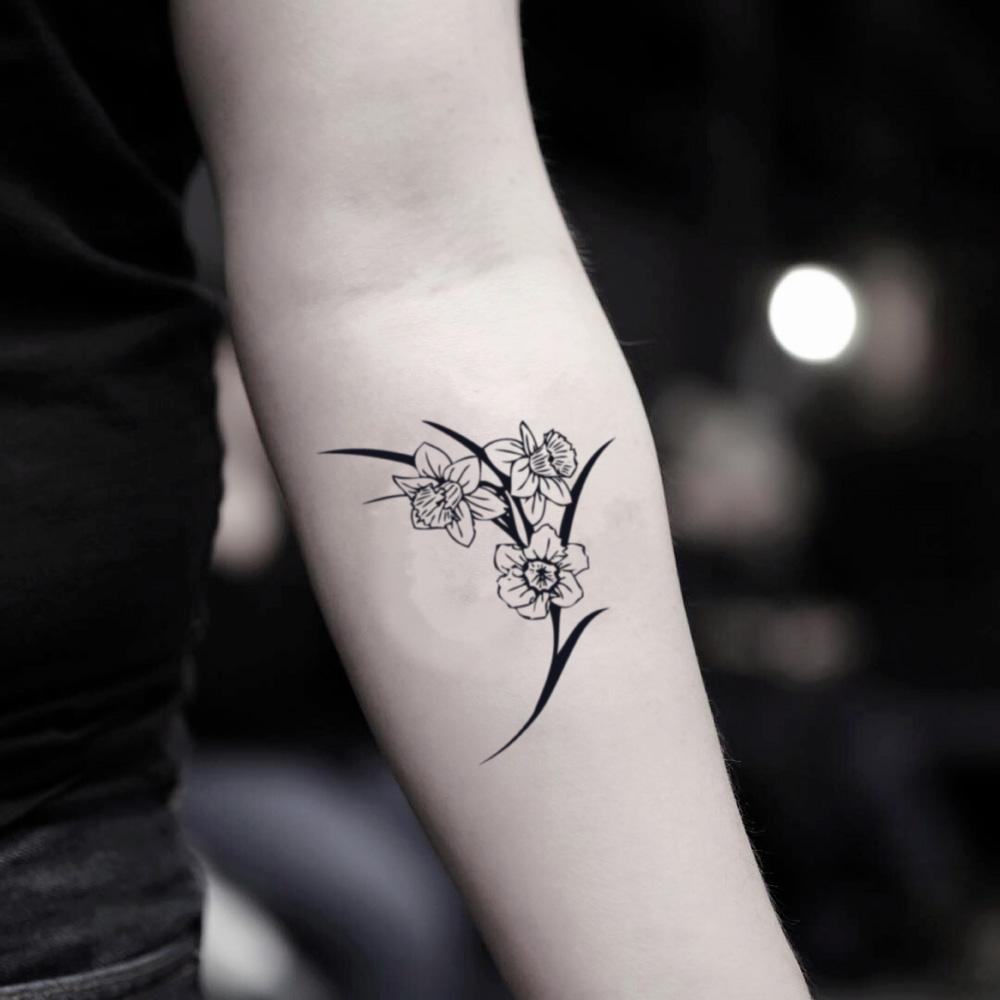 One line flower tattoo located on the wrist.