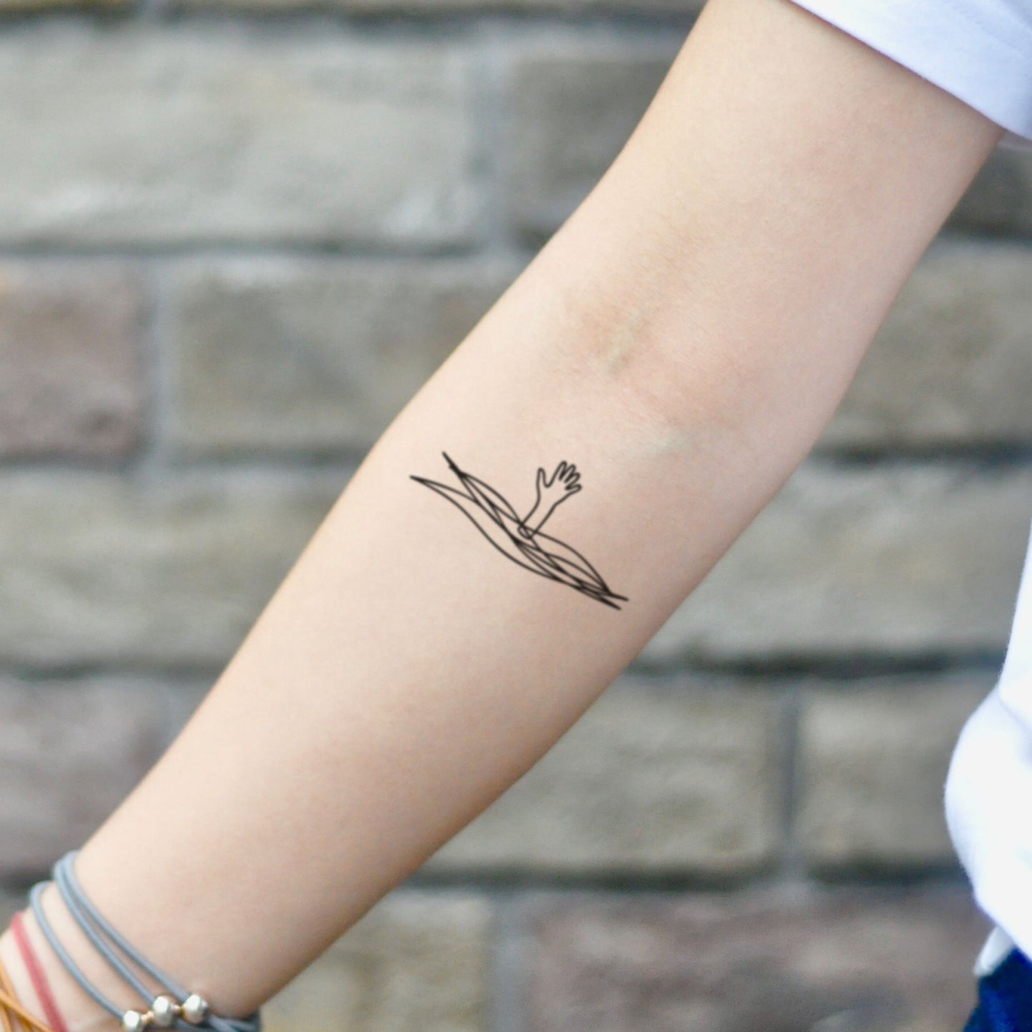 fake small drowning hand Illustrative temporary tattoo sticker design idea on inner arm