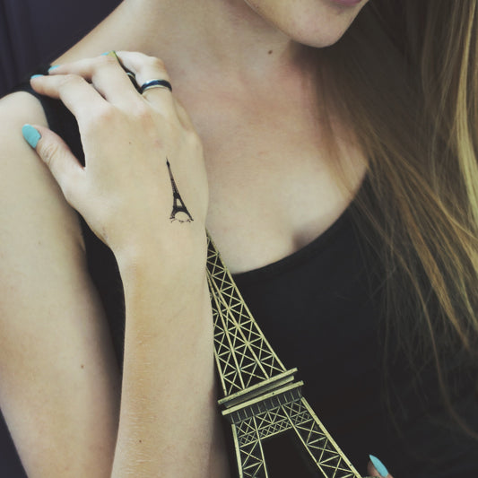 fake small paris eiffel tower illustrative temporary tattoo sticker design idea on wrist